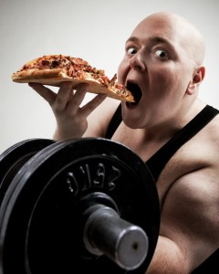 Un homme démontrant une forme physique avec une pizza et une barre.