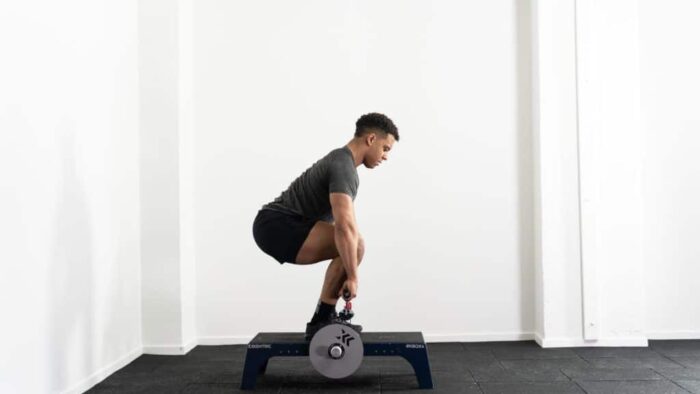 Un homme faisant un squat sur un banc de musculation.