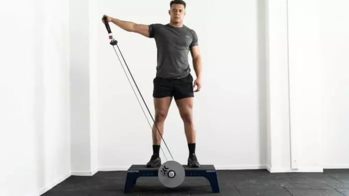 Un homme se tient debout sur une plateforme d’exercice avec une corde.