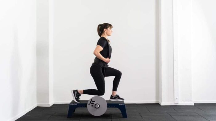 Une femme fait un squat sur un ballon d’exercice.