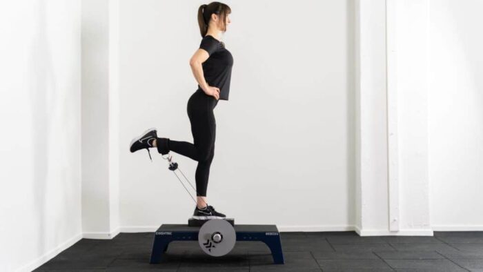 Une femme est debout sur un appareil d’exercice.